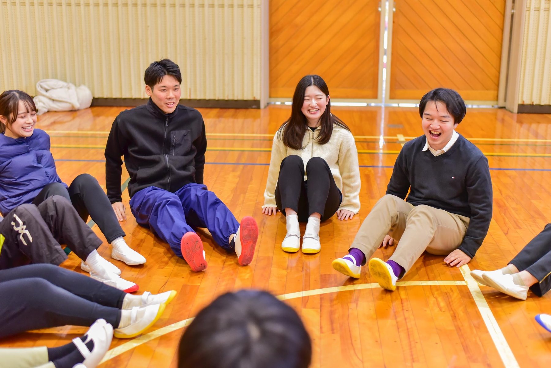 体育館で笑顔で活動する研修参加者